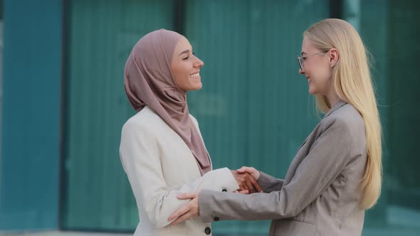 Smiling Millennial Women Indian Girl in Hijab and Young European Businesswoman Get Acquainted