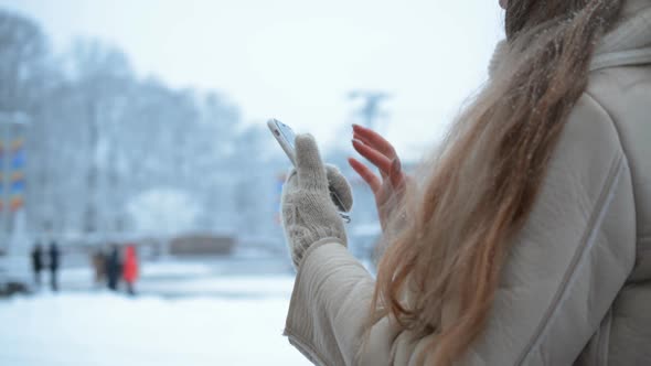Woman Hands Uses A Mobile Phone In Winter City