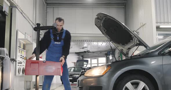 Car Service. Mechanic Is Adjusting Headlights. Low Beam, High Beam. Wide Shot