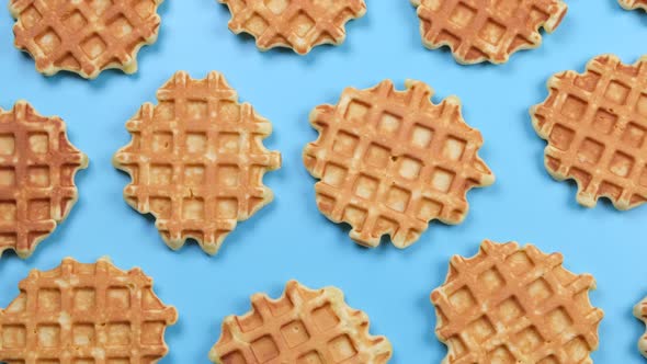 Rotating Background of Appetizing Sweet Waffles on a Blue Background