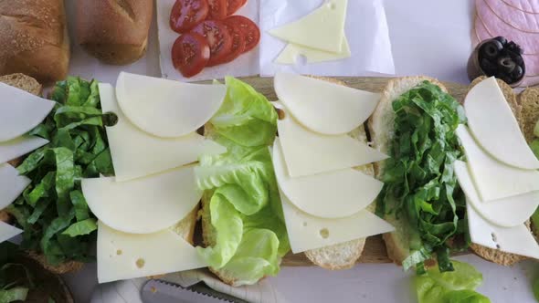 Step by step. Preparing fresh sub sandwich on white and wheat hoagies.