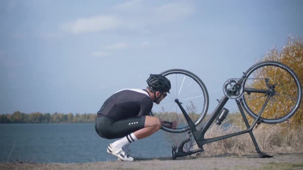 Bicyclist Repairing Wheel And Gears. Triathlete Fixes His Bicycle After Breakdown.