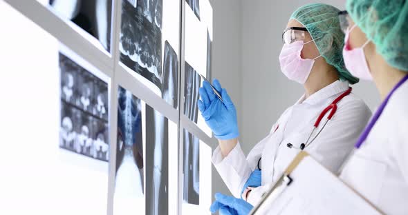 Doctors in Protective Masks and Glasses Looking at Xrays in Clinic Office  Movie Slow Motion