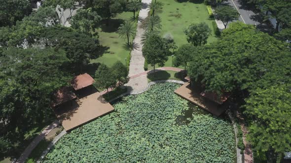 long wide aerial view of modern urban park featuring lakes, lush gardens, bridges, green space, path
