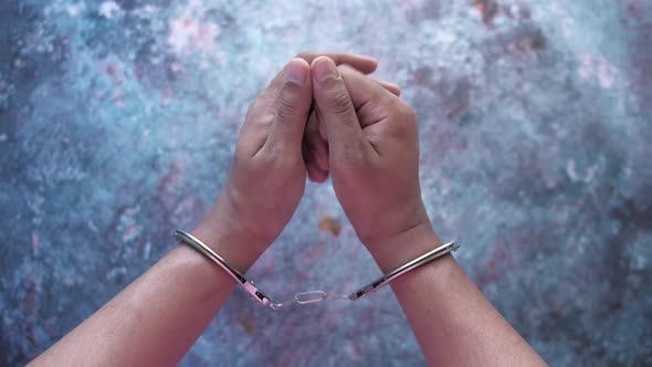 Man's Hand with Handcuff on Black Background., Top Down 