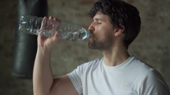 Man Drinks Water From Bottle in Gym