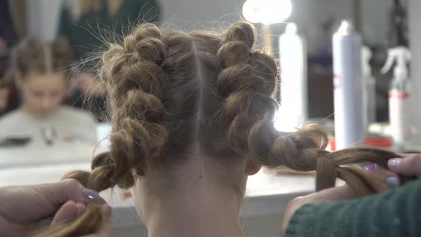 Hairdresser Makes Pigtails To a Girl