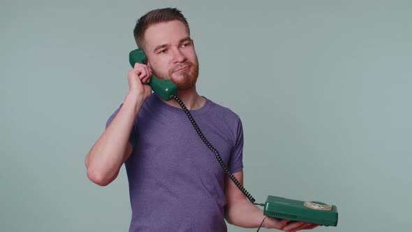 Crazy Sincere Young Man Talking on Wired Vintage Telephone of 80s Fooling Making Silly Funny Faces