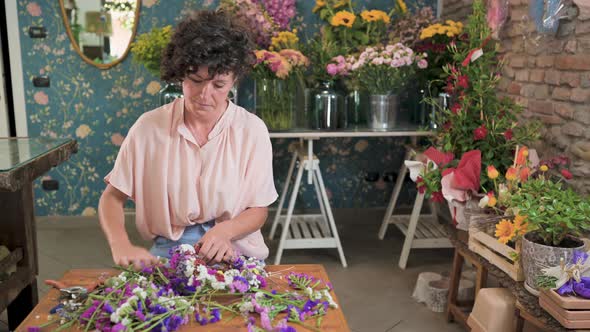 Woman creating flower wreath in florist shop