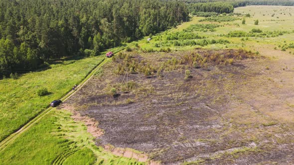 Burnt Grass on the Outskirts of the Field There is a Fire Engine