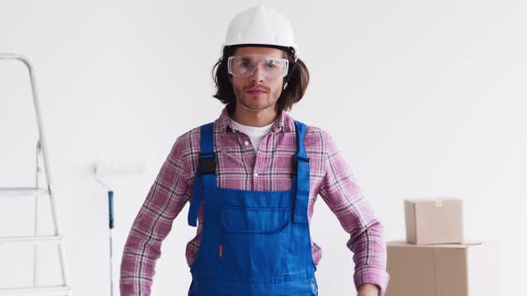 Confident Renovation Handyman Wearing Uniform with Protective Glasses and Helmet Looking at Camera