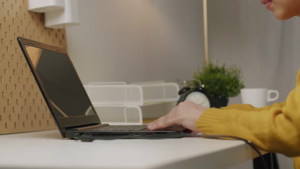 Businesswoman typing keyboard and scrolling touchpad on a laptop.