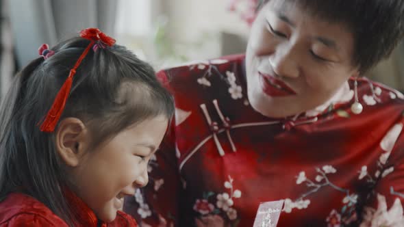 Mother Giving Chinese New Year Postcard to Daughter