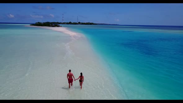 Romantic couple relax on relaxing island beach break by blue water and white sandy background of the