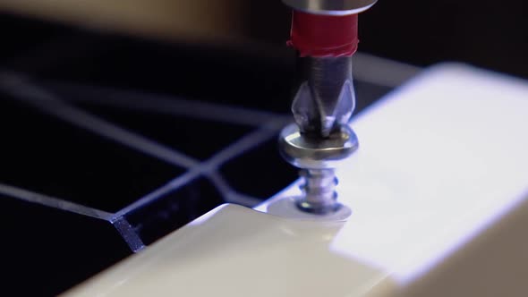 Master, Who Manufactures Furniture Sets the Dishwasher, Using a Screwdriver. Close-up