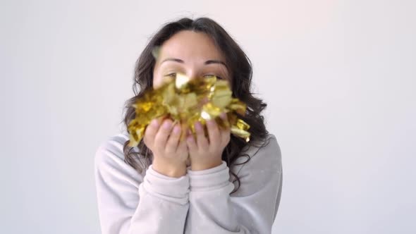 Pretty Brunette Blowing on Candy, Christmas Mood. Attractive Happy Girl Blowing Gold Glitter