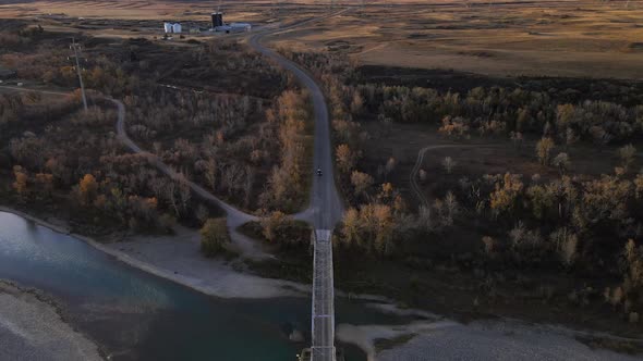 Still aerial footage of an old truss bridge made of steel in southern Alberta's countryside. Car app