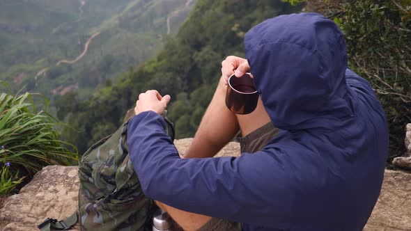 Young Man Drinking Tea In Mountains. Hiking Camping Lifestyle Concept