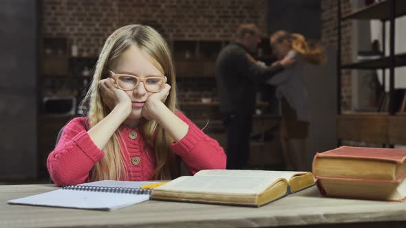 Upset Girl Studying While Her Parents Fighting