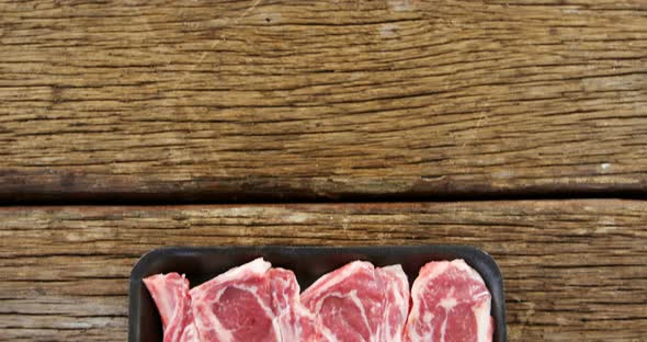 Sirloin steak in black container on wooden background