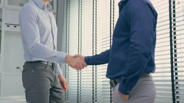 Close up of Caucasian young businessman handshake each other in office.