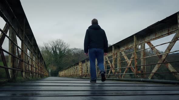 Man Walks On Old Train Bridge