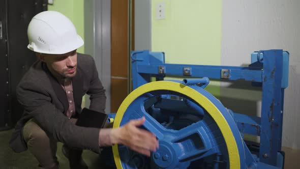 Technician in Helmet Checks Assembly Quality of New Elevator Electric Drive