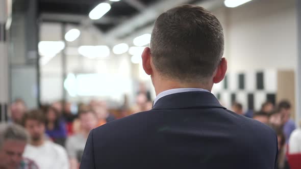 Business Man Presenting Training. Motivational Speech To People in Audience Hall