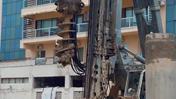 Earthmoving machine in construction site for drilling piles.