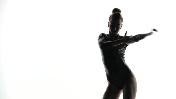 Silhouette of a Girl in Body Dancing in a White Studio