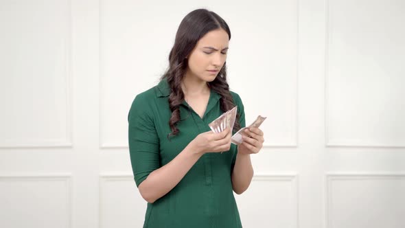 Confused Indian woman counting money