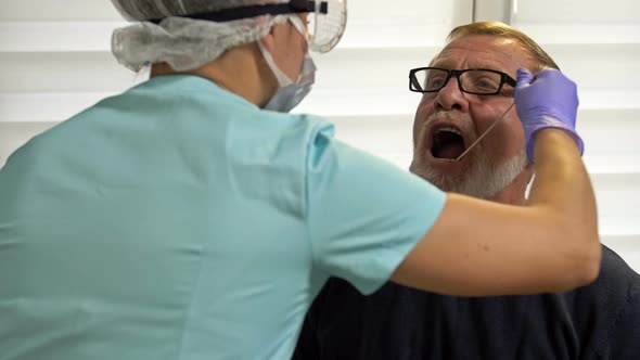 Laboratory Technician Takes Elderly Patient's Smear To Test for Coronavirus.