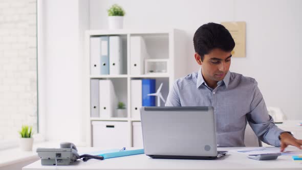 Businessman with Papers Typing on Laptop at Office 27