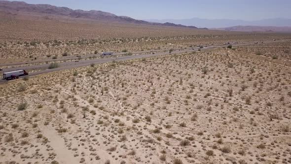 Driving desert highway with cars and trucks