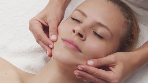 Young, healthy and beautiful woman gets massage therapy in the spa salon.