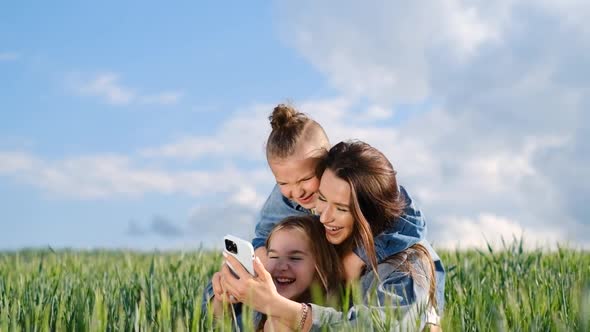Mom Daughter and Son Taking a Selfie on a Wheat Field on a Background of Sky