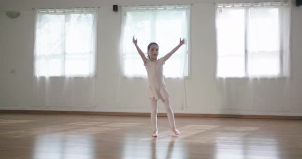 Little girl dancing alone in a studio