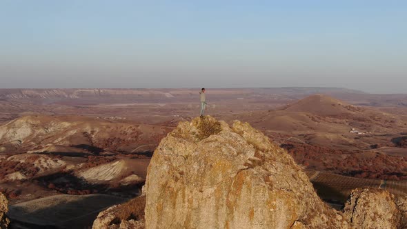 A Man Towers Over a Mountain Scenery Standing on Top