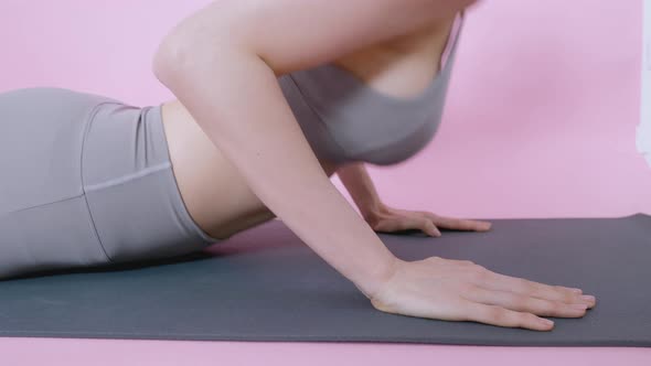 Stretching push up yoga pose of Asian woman exercise workout at home on isolate pink background