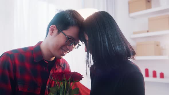 Asian Man Giving Bouquet of Red Roses to His Wife