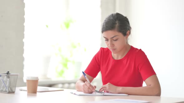 Indian Woman Writing on Paper in Office