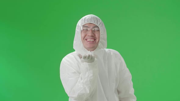 Male Wear Protective Equipment Uniform Ppe Blowing Kisses To A Camera In The Green Screen Studio