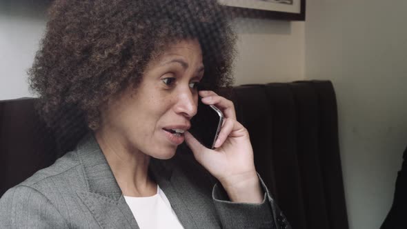 Afro American Businesswoman talking on phone in cafe