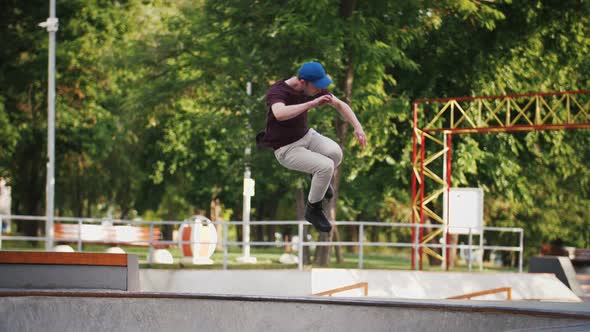 Aggressive Inline Roller Skater Doing Tricks in Concrete Skatepark Outdoors with Beautiful