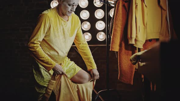 Mime Puts on Yellow Stage Costume for Performance in Circus