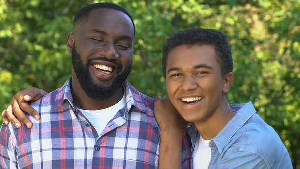 Cheerful Afro-American Teenager Hugging Smiling Father, Happy Family Portrait