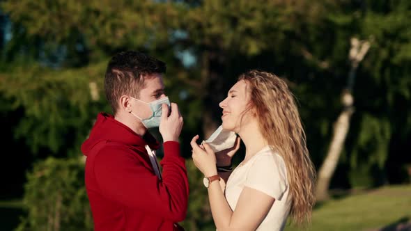 Young Family Couple in Love Medical Protective Masks in City Sunset