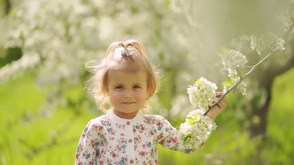 Little Girl at Flowering Tree in Garden