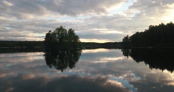 An aerial footage of a calm lake during sunset in lakeland finland.