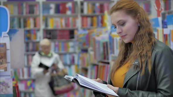 Portrait of a Young Beautiful Woman with Bright Red Hair in Glasses, Pretty Girl Reading in Book